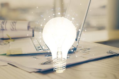 Bilgisayar ofisinde ampul simgesi hologramıyla birlikte. Çoklu maruz kalma. Fikir kavramı.