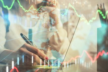 Bilgisayarda ve finansal grafik hologramında kadın eli yazarken çift pozlama. Borsa analizi kavramı.