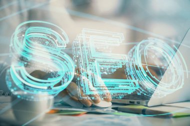 Arka planda bilgisayarla çalışan bir adamla iki kez simgeye maruz kalıyoruz. Arama motoru optimizasyonu kavramı.