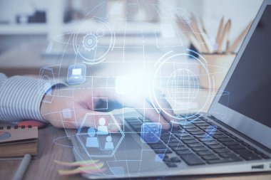 Sosyal ağ temalı hologramda iş adamı arka planda bilgisayar üzerinde çalışıyor. Dünya çapında ağ kavramı. Çoklu pozlama.