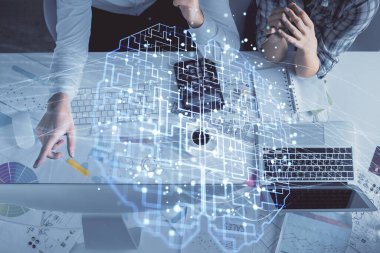 Kadın ve erkeğin birlikte çalışması ve insan beyin hologramı çizimi. Beyin fırtınası konsepti. Bilgisayar arkaplanı. Üst Görünüm.