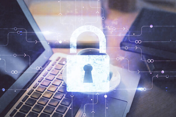 Double exposure of desktop with computer and lock icon hologram. Concept of data safety.