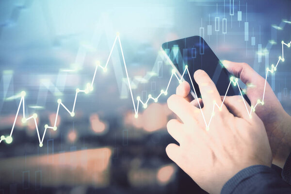 Double exposure of mans hands holding and using a digital device and forex graph drawing. Financial market concept.