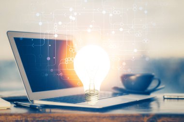 Bilgisayar ofisinde ampul simgesi hologramıyla birlikte. Çoklu maruz kalma. Fikir kavramı.