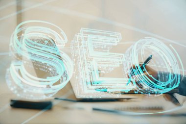 Arka planda bilgisayarla çalışan bir adamla iki kez simgeye maruz kalıyoruz. Arama motoru optimizasyonu kavramı.