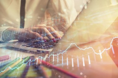 Bilgisayarda ve finansal grafik hologramında kadın eli yazarken çift pozlama. Borsa analizi kavramı.