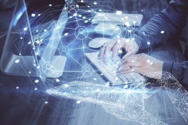 Sosyal ağ temalı hologramda iş adamı arka planda bilgisayar üzerinde çalışıyor. Dünya çapında ağ kavramı. Çoklu pozlama.