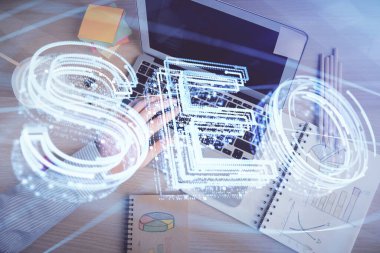 Bilgisayar klavyesinin ve SEO hologram çiziminin üzerine yazı yazan bir adamın eline çok kez maruz kalmış. Üst Manzara. Arama optimizasyon kavramı.