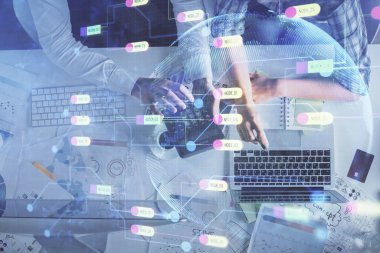 Kadın ve erkeğin birlikte çalışması ve veri temalı hologram çizimi. Bilgisayar arkaplanı. Üst Görünüm.