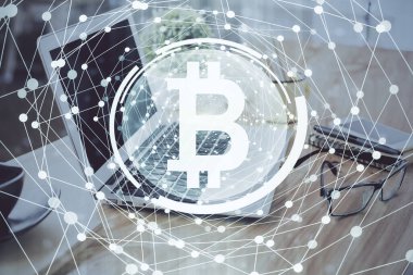 Engelleme zinciri ve kripto ekonomi temalı hologram ve bilgisayar geçmişi olan bir masa. Bitcoin kripto para kavramı.