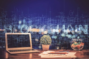 Engelleme zinciri ve kripto ekonomi temalı hologram ve bilgisayar geçmişi olan bir masa. Bitcoin kripto para kavramı.