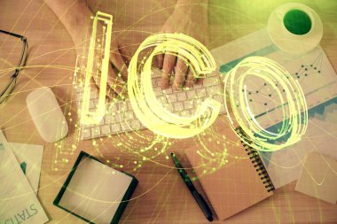 Bilgisayar klavyesinin ve şifreli para birimi temalı hologram çiziminin üzerine iki kez yazılan el pozu. Üst Manzara. Engelleme zinciri kavramı.