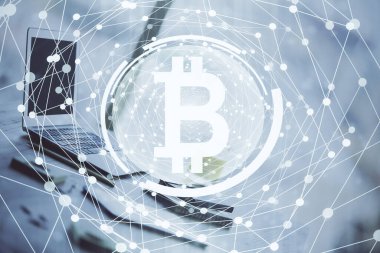 Engelleme zinciri ve kripto ekonomi temalı hologram ve bilgisayar geçmişi olan bir masa. Bitcoin kripto para kavramı.