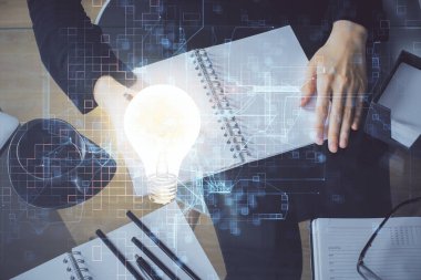 Arka planda not alan bir kadının eline ampul çizmek. Fikir kavramı. Çift pozlama