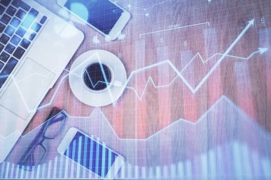 Masaüstü üzerinde telefonla finansal haritaya çoklu maruz kalma. Üst Manzara. Mobil ticaret platformu kavramı.