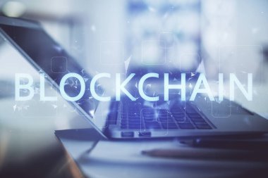 Engelleme zinciri ve kripto ekonomi temalı hologram ve bilgisayar geçmişi olan bir masa. Bitcoin kripto para kavramı.