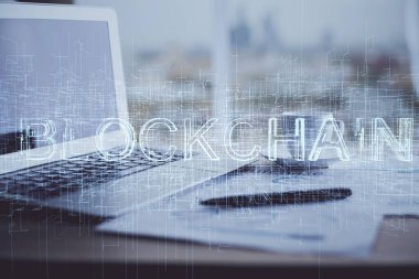 Engelleme zinciri ve kripto ekonomi temalı hologram ve bilgisayar geçmişi olan bir masa. Bitcoin kripto para kavramı.