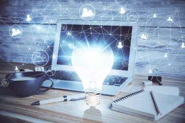 Bilgisayar ofisinde ampul simgesi hologramıyla birlikte. Çifte maruziyet. Fikir kavramı.