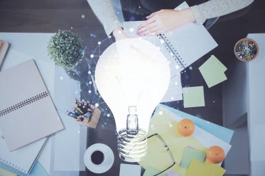 El üstünde tutulan ampul hologramı notlar alıyor. Fikir kavramı. Çift pozlama