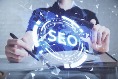 Kredi kartı ve SEO çizimi tutan bir adamın ellerine iki kez maruz kalmış. İnternet E-ticaret konseptinde arama motoru optimizasyonu.