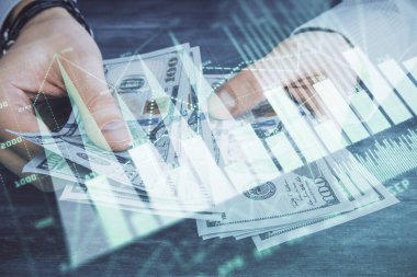 Finansal grafiğe çoklu pozlama hologram, Amerikan dolarları ve insan eli. Analiz kavramı.