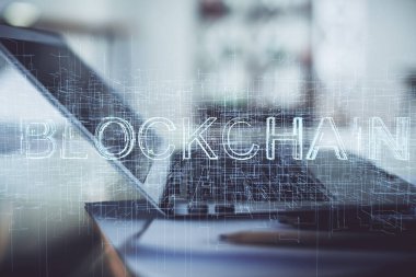 Engelleme zinciri ve kripto ekonomi temalı hologram ve bilgisayar geçmişi olan bir masa. Bitcoin kripto para kavramı.