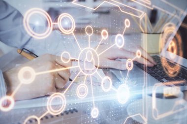 Sosyal ağ temalı hologramda iş adamı arka planda bilgisayar üzerinde çalışıyor. Dünya çapında ağ kavramı. Çoklu pozlama.