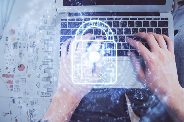 Multi exposure of mans hands typing over computer keyboard and lock hologram drawing. Top view. Technology concept.