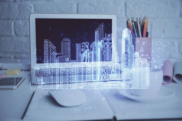 Desktop computer background in office and big town buildings hologram drawing. Double exposure. Smart city concept.