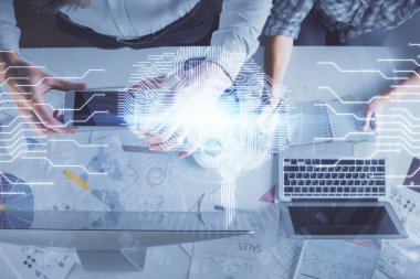 Kadın ve erkeğin birlikte çalışması ve insan beyin hologramı çizimi. Beyin fırtınası konsepti. Bilgisayar arkaplanı. Üst Görünüm.