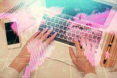 Bilgisayar ve finansal temalı hologram çizimleri üzerinde çalışan kadın elleri çift pozlama. Üst Manzara. İş konsepti.