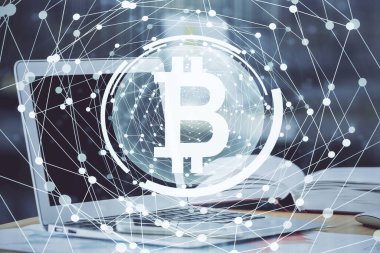 Engelleme zinciri ve kripto ekonomi temalı hologram ve bilgisayar geçmişi olan bir masa. Bitcoin kripto para kavramı.