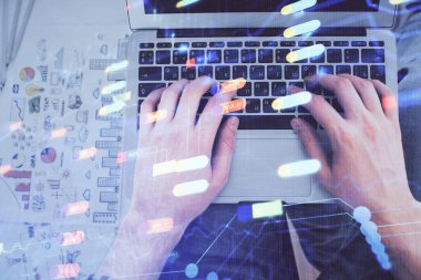 İnsan elinin bilgisayar klavyesi ve veri temalı hologram çiziminin üzerine yazarken çoklu pozlama. Üst Manzara. Teknoloji konsepti.