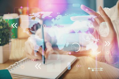 Dünya haritası hologramı ve veri tema simgeleriyle notlar alan ellerin çifte pozlanması. Küresel bilgisayar verisi kavramı.