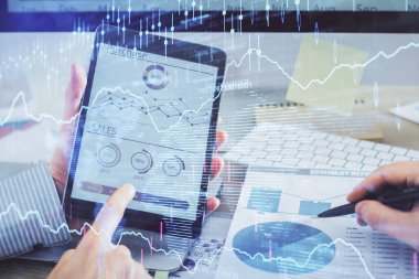 Bir adamın el ele tutuşması ve telefon ve finansal çizim kullanması. Pazar analizi kavramı.