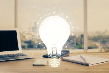 Bilgisayar ofisinde ampul simgesi hologramıyla birlikte. Çifte maruziyet. Fikir kavramı.