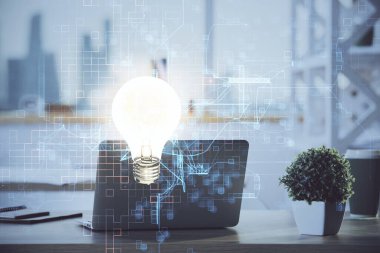 Bilgisayar ofisinde ampul simgesi hologramıyla birlikte. Çifte maruziyet. Fikir kavramı.