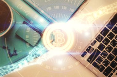Masaüstü arkaplanındaki bilgisayarın üzerinden engelleme temalı hologram çizimleri. Üst Manzara. Çoklu maruz kalma. Kripto ekonomi kavramı.