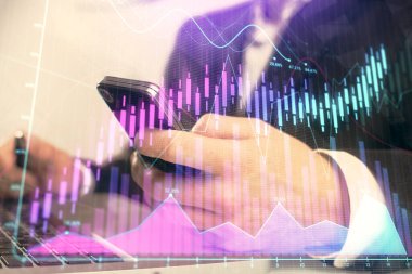 Dijital telefon ve forx grafik çizimi kullanarak adamın elini tutarken birden fazla pozlama. Finansal piyasa kavramı.