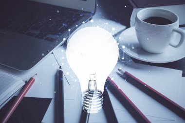 Bilgisayar ofisinde ampul simgesi hologramıyla birlikte. Çifte maruziyet. Fikir kavramı.