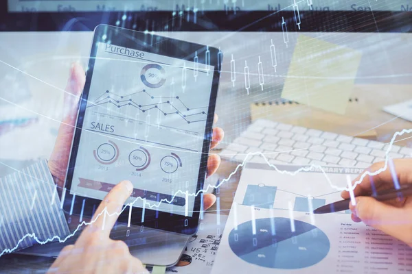 Bir adamın el ele tutuşması ve telefon ve finansal çizim kullanması. Pazar analizi kavramı.