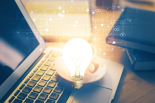 Bilgisayar ofisinde ampul simgesi hologramıyla birlikte. Çifte maruziyet. Fikir kavramı.