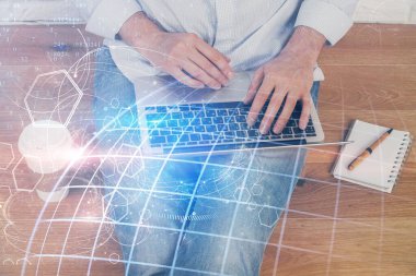 Arka planda bilgisayarla çalışan bir adamla dünya haritası hologramına çift pozlama. Dünya çapında ağ kavramı.