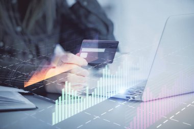 İnternetten alışveriş yapan kadının elinde kredi kartı ve mali grafik çizimi var. Borsa E-ticaret kavramı.