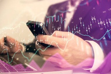 Dijital telefon ve forx grafik çizimi kullanarak adamın elini tutarken birden fazla pozlama. Finansal piyasa kavramı.