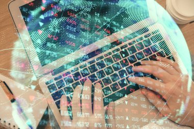 İnsan elinin bilgisayar klavyesi ve iş temalı hologram çiziminin üzerine iki kez yazı yazması. Üst Manzara. Finans piyasası kavramı.