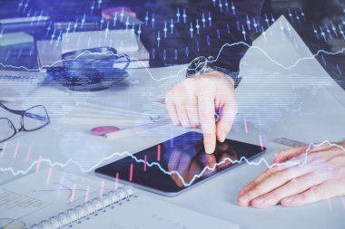 Bir adamın elini tutarken ve dijital bir cihaz ve ön grafik çizimi kullanırken çift pozlama. Finansal piyasa kavramı.