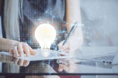 El üstünde tutulan ampul hologramı notlar alıyor. Fikir kavramı. Çift pozlama