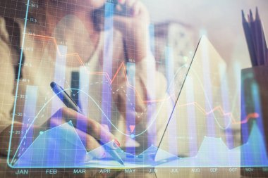 Bilgisayarda ve finansal grafik hologramında kadın eli yazarken çift pozlama. Borsa analizi kavramı.