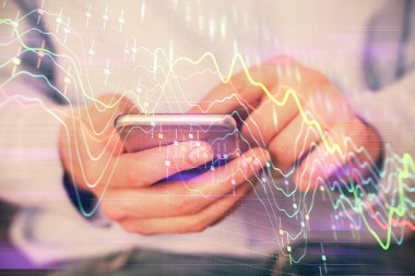 Dijital telefon ve forx grafik çizimi kullanarak adamın elini tutarken birden fazla pozlama. Finansal piyasa kavramı.